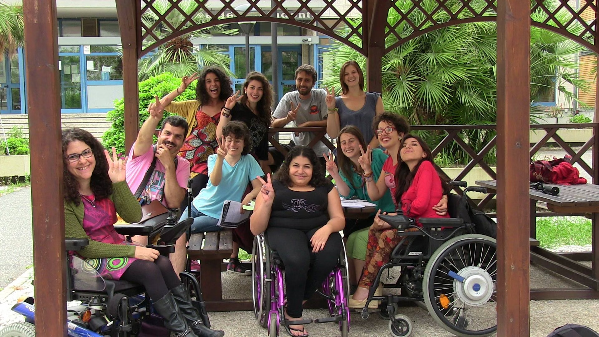 Un gruppo di persone, alcune in carrozzina, riunite sotto un gazebo.