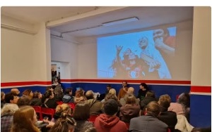 Il pubblico assiste a una proiezione nella sala della Casa della Socialità.